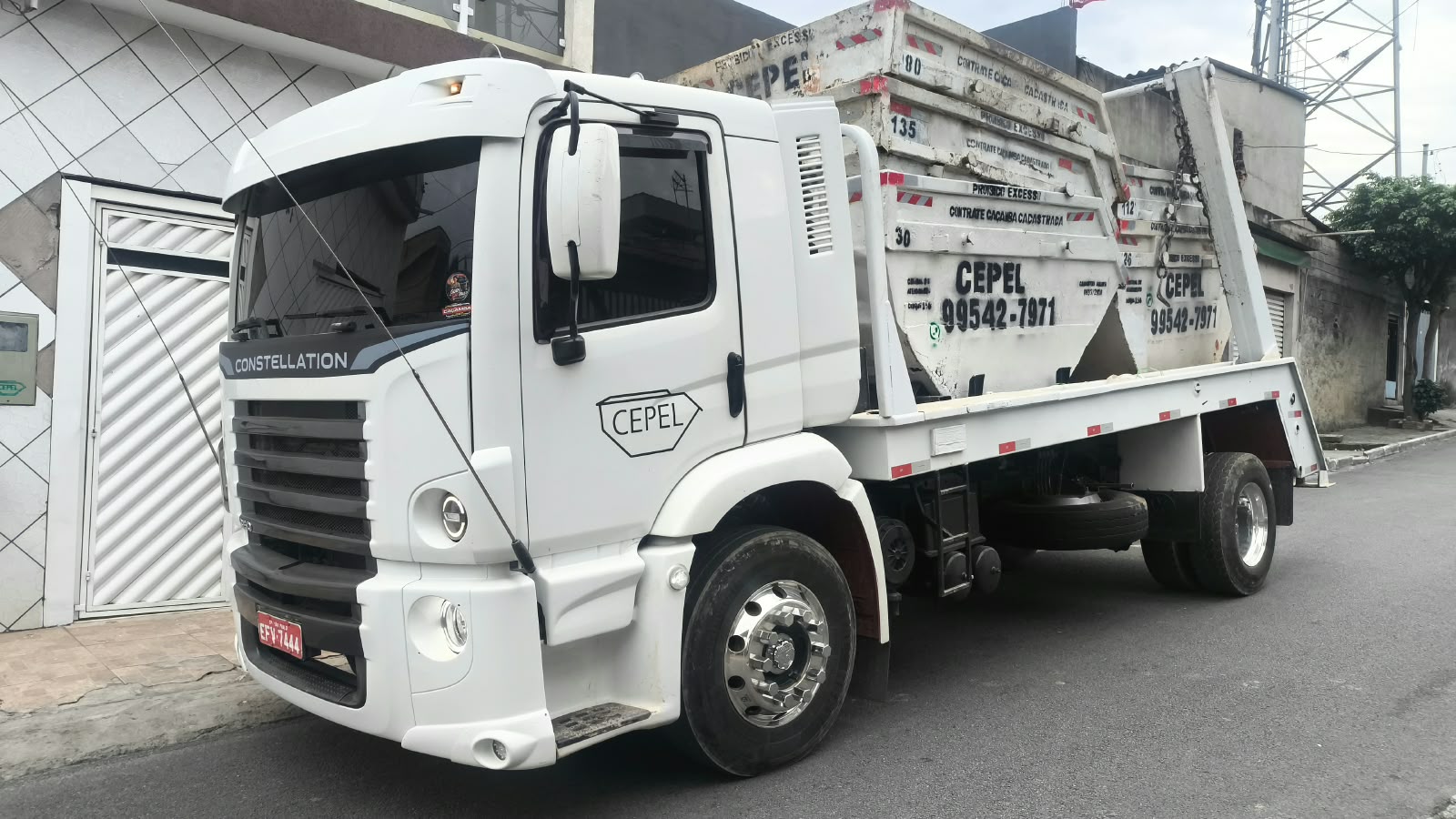 Caminhão poliguindaste CEPEL carregando caçambas estacionárias